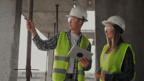equipo de construcción o arquitecto y constructor o trabajador con cascos discuten un plan de construcción de andamios o un plan o una lista de comprobación