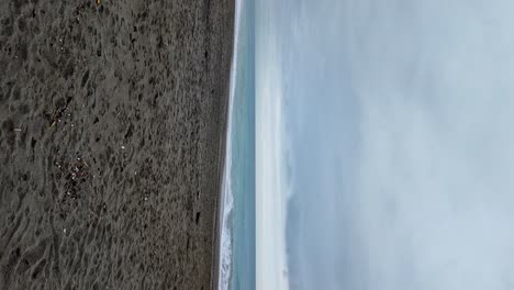 Serene-beach-by-the-sea-on-a-cloudy-day---vertical-video