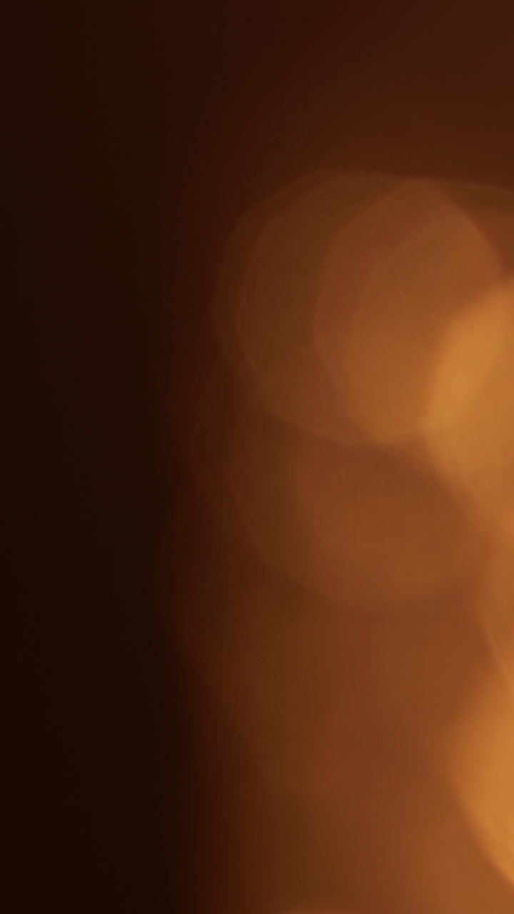 Fughe di luce bokeh calde su sfondo scuro