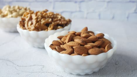 almendras y nueces en tazones blancos pequeños