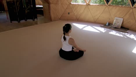 yoga practice in a zen geometric outdoor studio, with a focus on mindfulness and peace, sitting cross legged with steady breathing