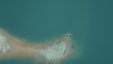 Aerial-4k-shot-from-overhead-of-a-canoe-close-to-land-in-a-lake