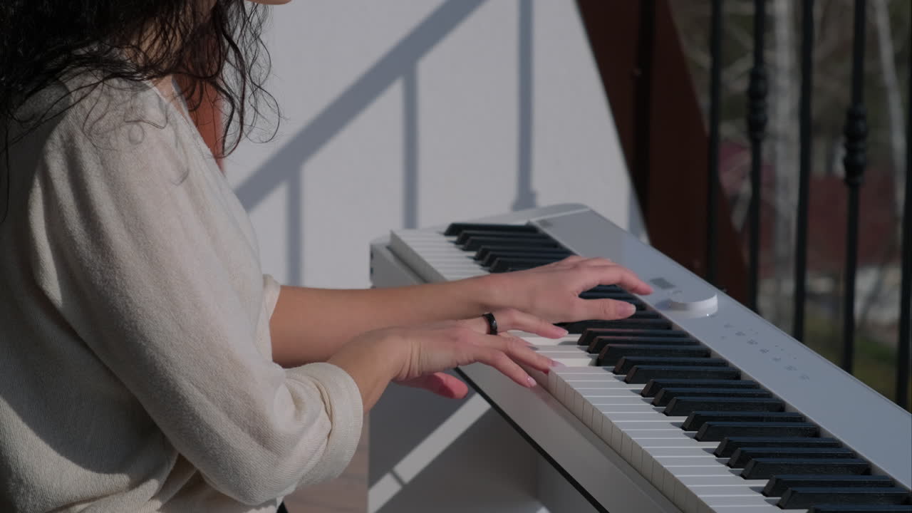 mujer tocando el piano en un balcón