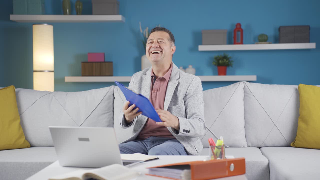 가정 사무직 노동자 남자가 서류 파일을 보고 있습니다.