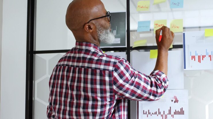 Senior male executive wring on sticky notes 4k