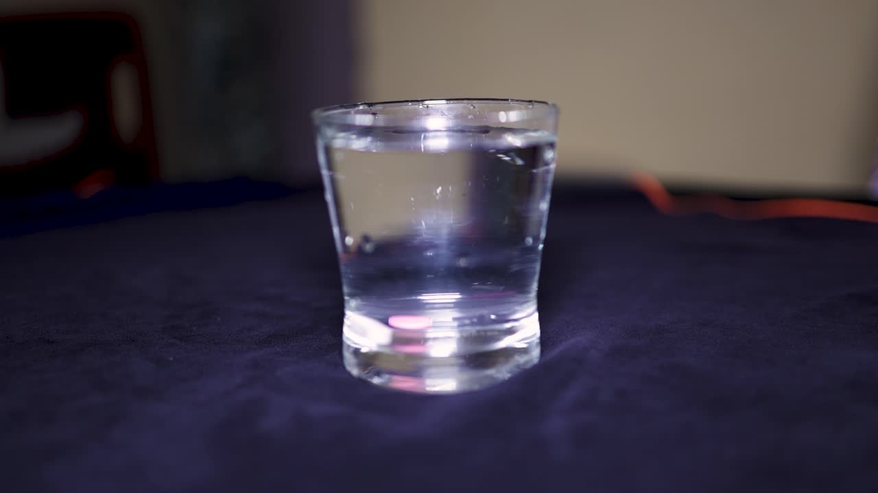medicine tablet dropping in glass of water at indoor
