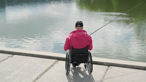 person with a physical disability who uses wheelchair fishing from fishing pier