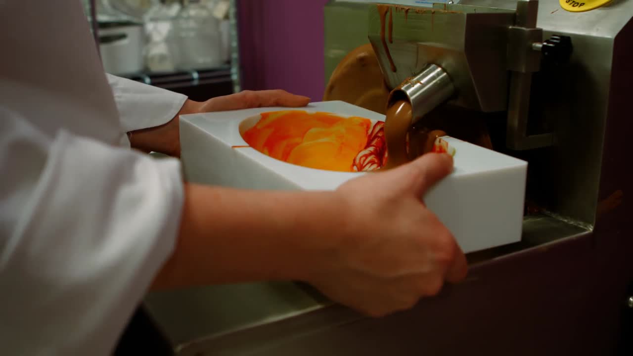 trabajador llenando el molde con chocolate derretido