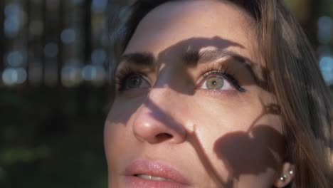 la luz del sol proyecta la sombra de la rama del árbol en el rostro de la mujer