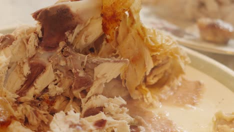 roast chicken carcass stripped of meat and served by chef with bones and steam rising. slow motion food footage.