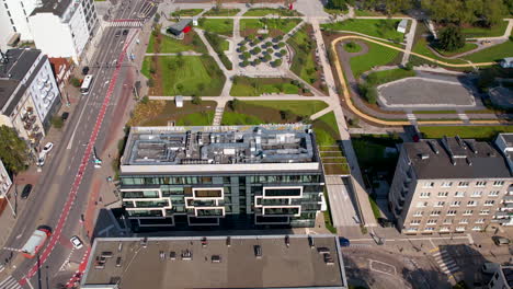 aerial view of modern buildings adjacent to a beautifully landscaped park in the city