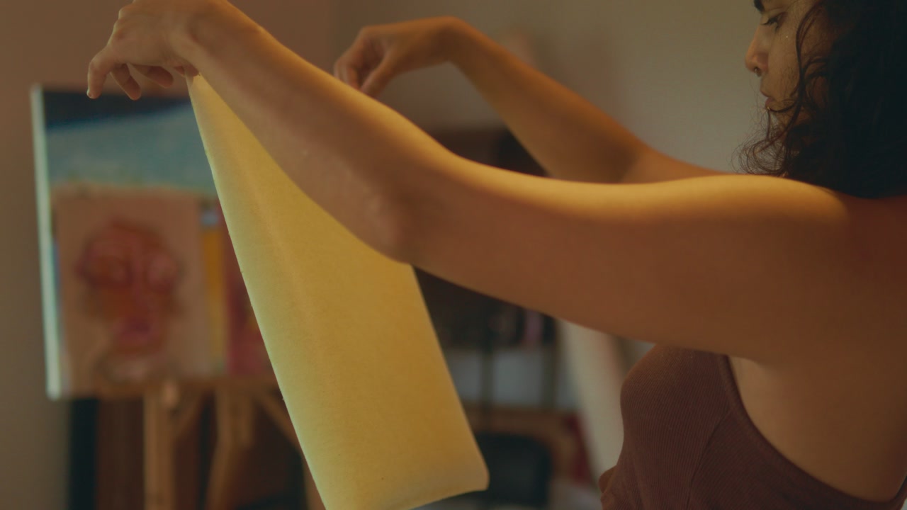 Woman holding paper sheet in indoor studio preparing for creative work calm lifestyle artistic moment