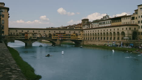 Historische-Brücke-Ponte-Vecchio-Mit-Kajakfahrern-Im-Wasser,-Florenz,-Italien