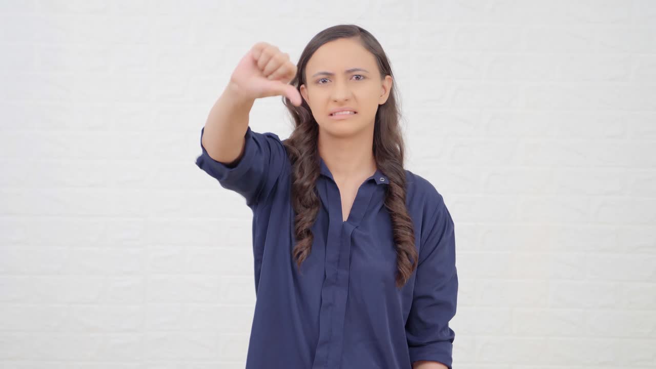 chica india mostrando los pulgares hacia abajo