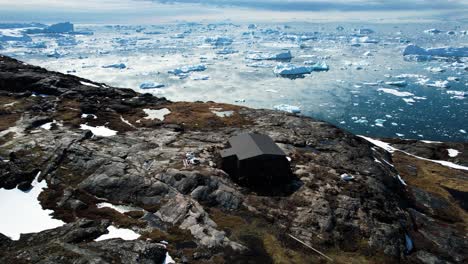 un sinfín de icebergs derritiéndose y edificios remotos en groenlandia, vista aérea