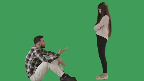 toma amplia de la hija y el padre discutiendo en el fondo de chromakey. hombre caucásico sentado como adolescente de pie y gestando no sacudiendo la cabeza. desacuerdo, adolescencia. cine 4k prores hq.
