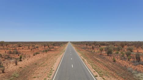 mujer caucásica caminando por el largo y sinuoso camino de uluru