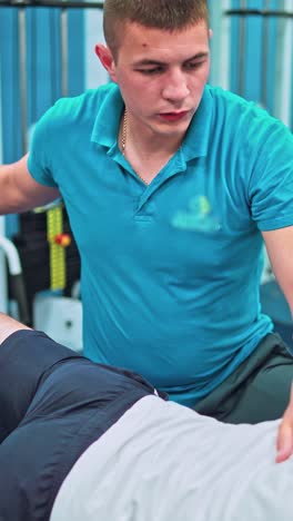 young man doing exercises under physiotherapist supervision