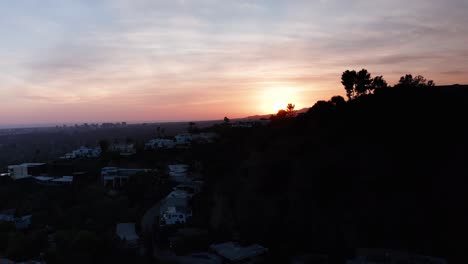 Aerial-rising-and-panning-shot-of-Beverly-Hills-mansions-on-hillside-during-sunset