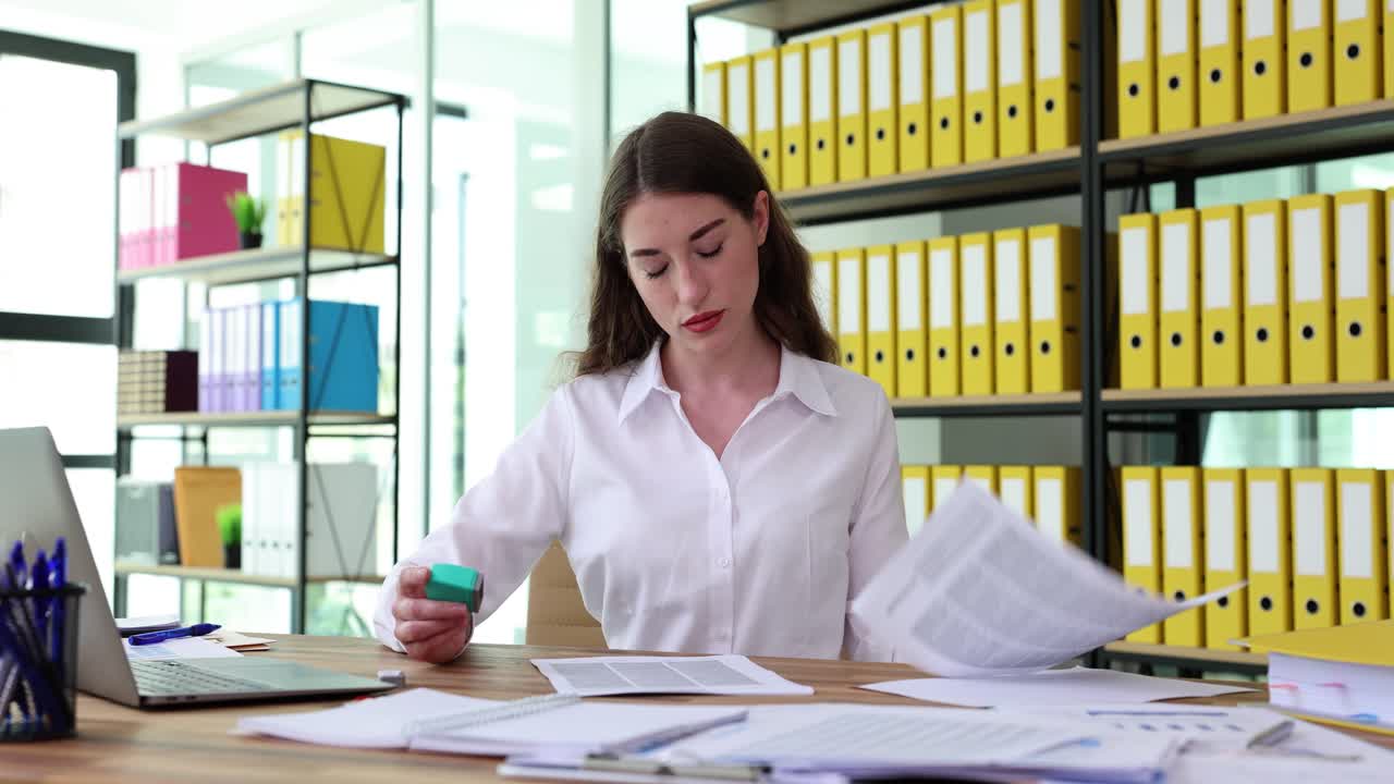 Professional Woman Stamping Documents in an Office