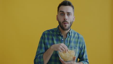man surprised while eating chips
