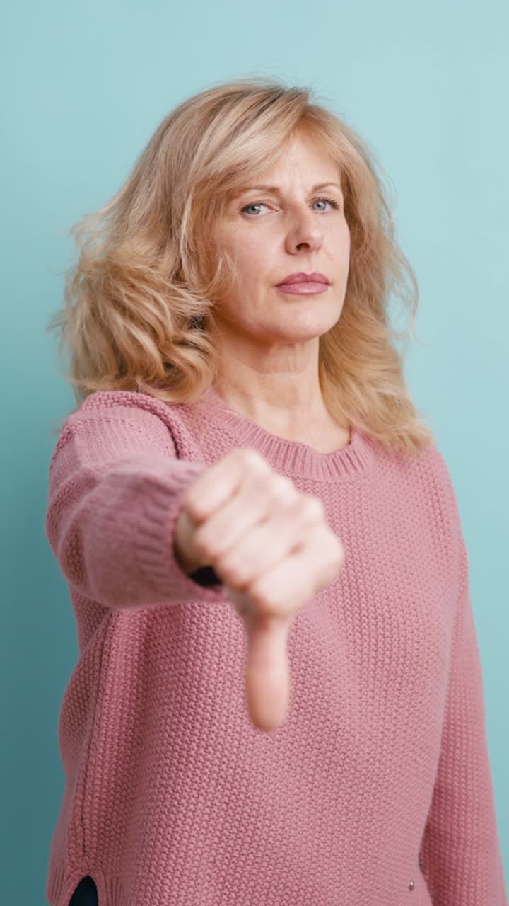 Donna che fa il gesto del pollice in giù con un'espressione scontenta