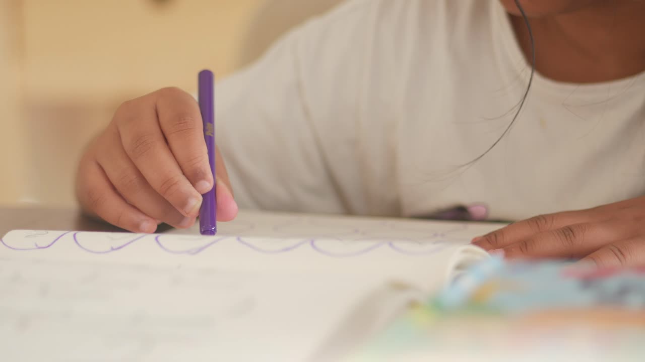 Child drawing in a notebook with a marker