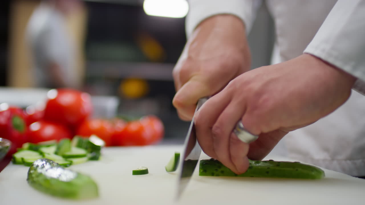 Chef Slicing Fresh Cucumber in Restaurant Kitchen