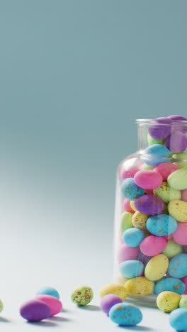 vertical video of vase with colorful easter eggs on blue background with copy space