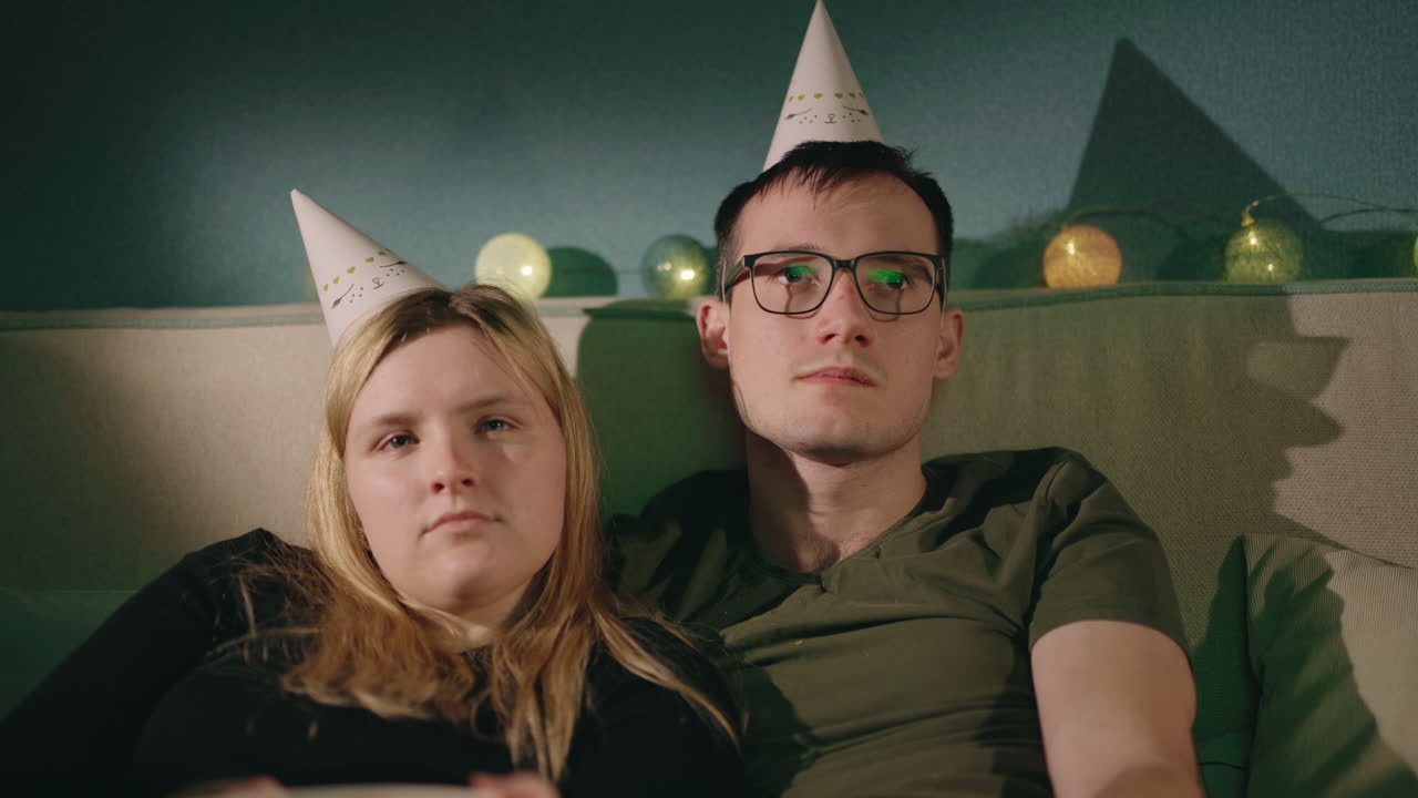 부부가 집에서 휴식을 취하고 영화를 보고 있습니다.