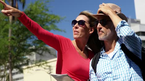 una pareja madura está mirando un mapa y señalando