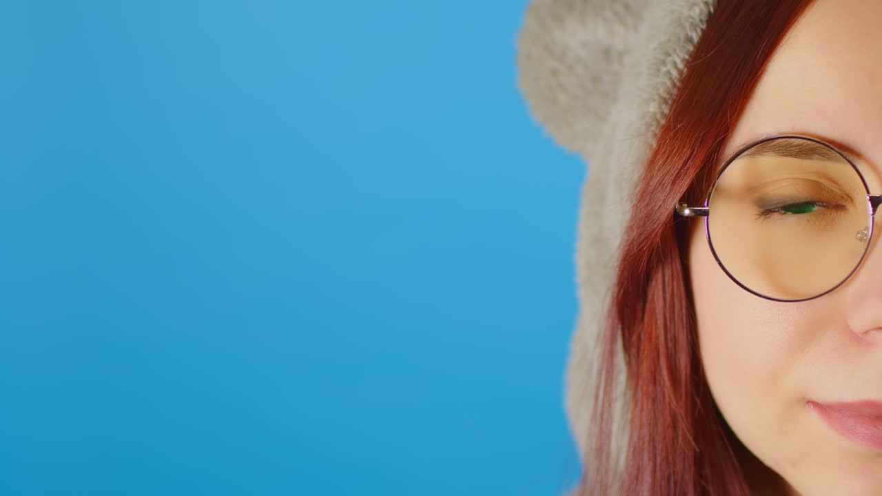 파란색 배경에 여성 얼굴의 일부와 텍스트를위한 공간. 안경을 입은 여성의 초상화가 카메라를보고 있습니다. 배너. chromakey.