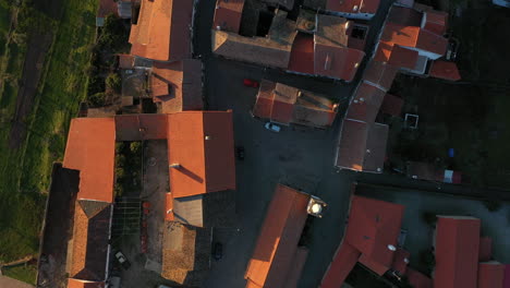 aerial top down shot over sunset lights on rooftops of rural portuguese village