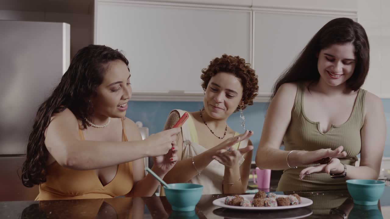 Three friends having fun making sweets in the kitchen