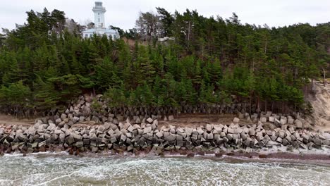 A-rocky-shoreline-with-a-lighthouse-in-the-distance