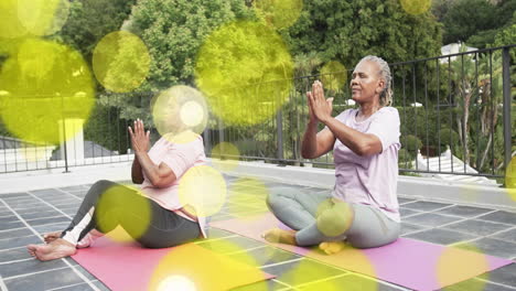 practicing yoga on mats, two women with yellow bokeh lights animation