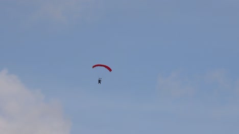 parachutist gliding down on a clear day