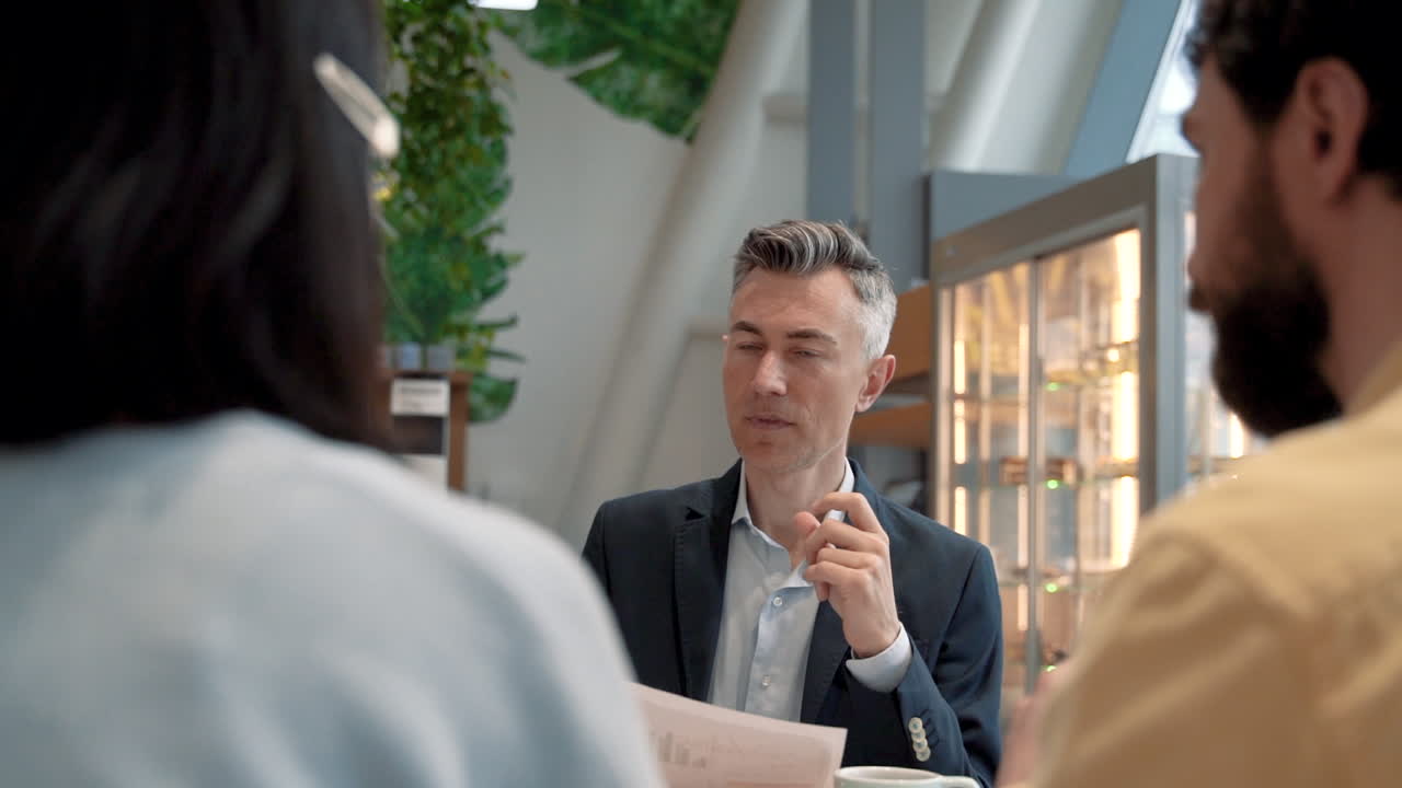 매력적인 사업가가 커피숍에서 일하기 위해 두 사람을 인터뷰합니다 1