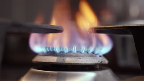 closeup of starting the gas burner for cooking dinner, blue flames