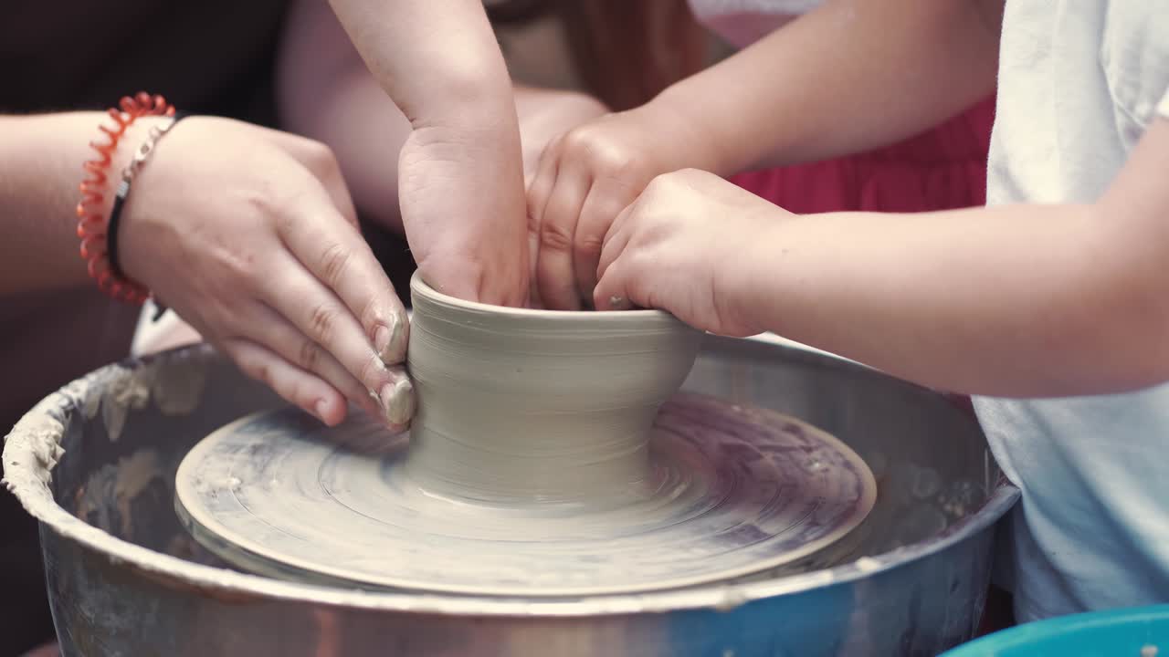 abuela con unos nietos hacen jarras en cerámica