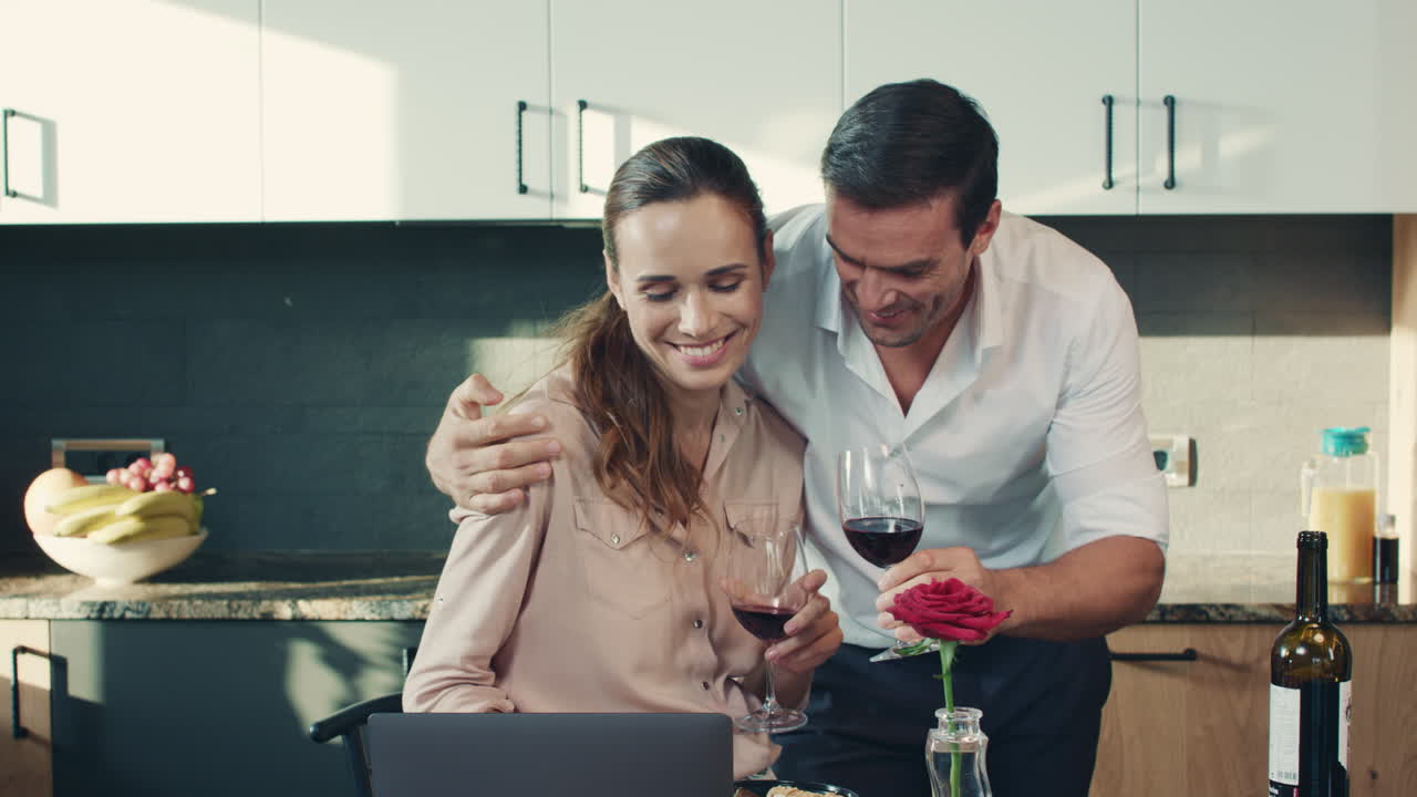 Coppia felice che beve vino rosso in una casa di lusso