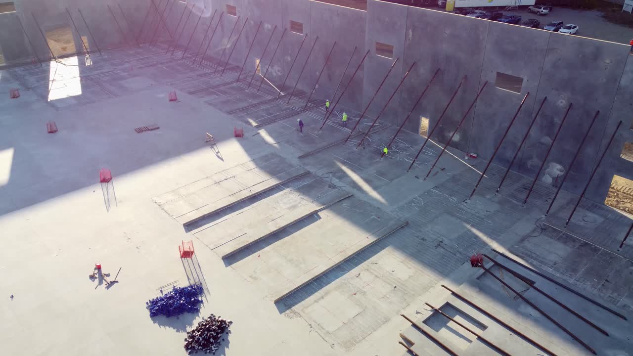 건설 현장에서 콘크리트 패널 작업을 하는 남성의 드론 돌리