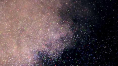 la explosión de pequeñas partículas coloridas en cámara lenta