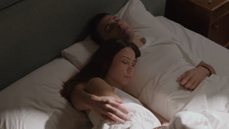 un couple qui dort dans un lit.