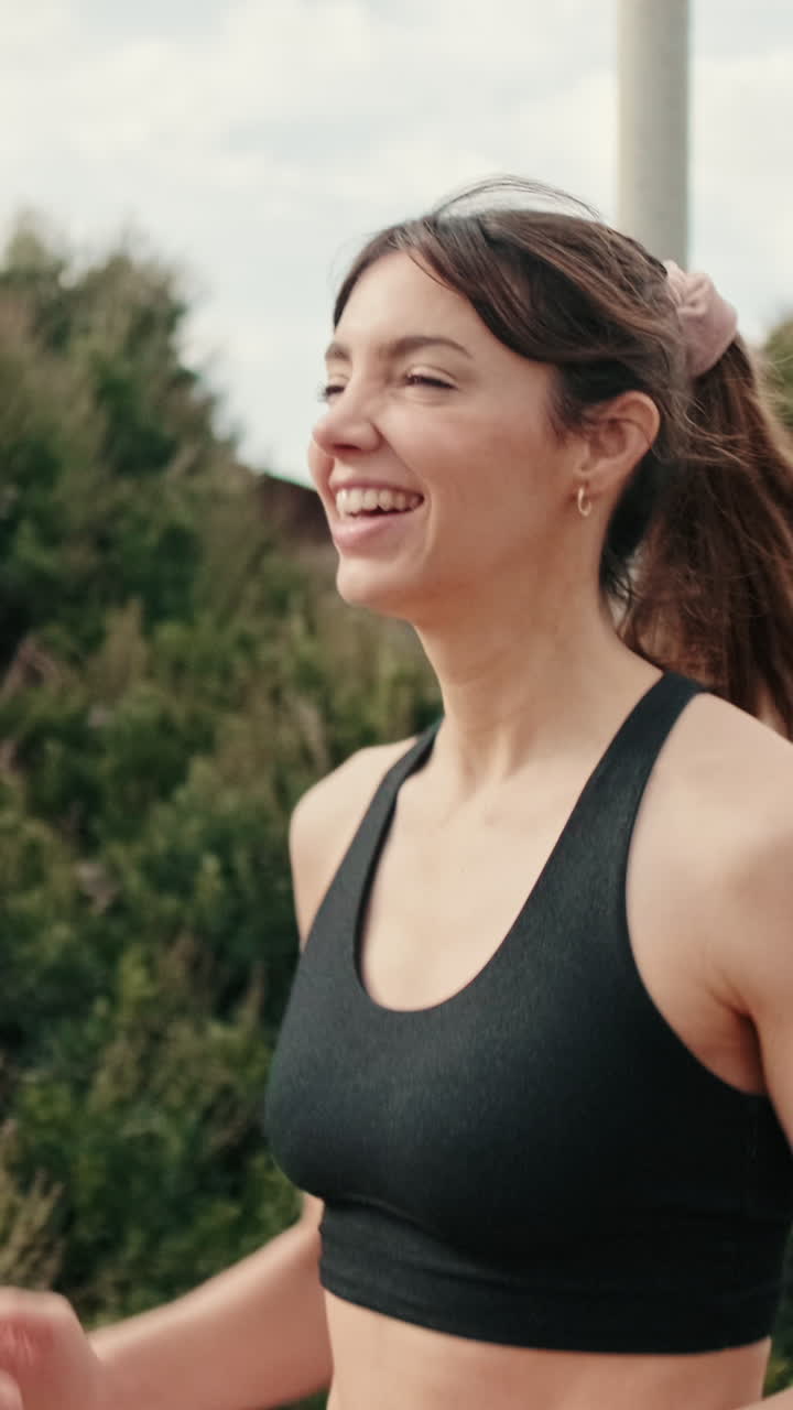 Giovane donna che sorride mentre corre all'aperto