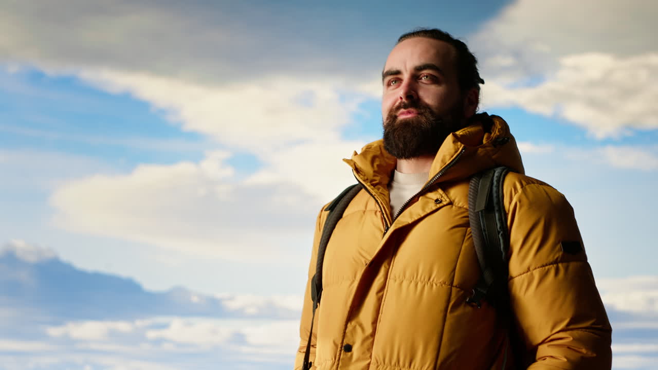 un excursionista con ropa cálida mira la cordillera panorámica