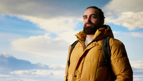 un excursionista con ropa cálida mira la cordillera panorámica