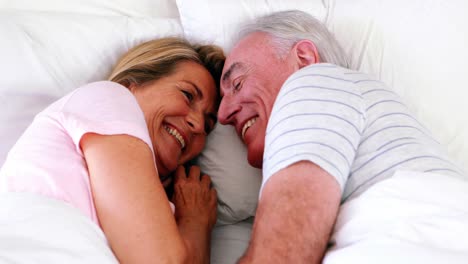 Happy-senior-couple-lying-on-bed