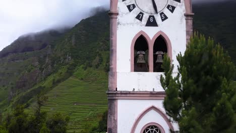 Aerial-circling-ascending-around-Fatima-Chapel-clock-tower-in-Madeira-island,-Portugal