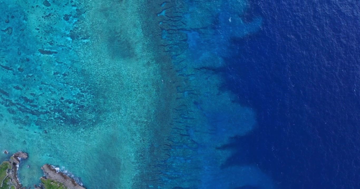 Toma aérea de arrecife de coral y océano en Okinawa, Japón.